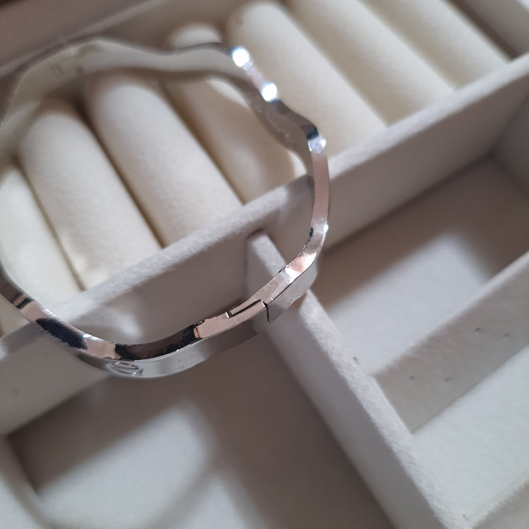 دستبند بنگل موجدار لولایی نقرهای براق با حکاکی Cartier | طراحی لوکس و مینیمال برند استینلس استیل