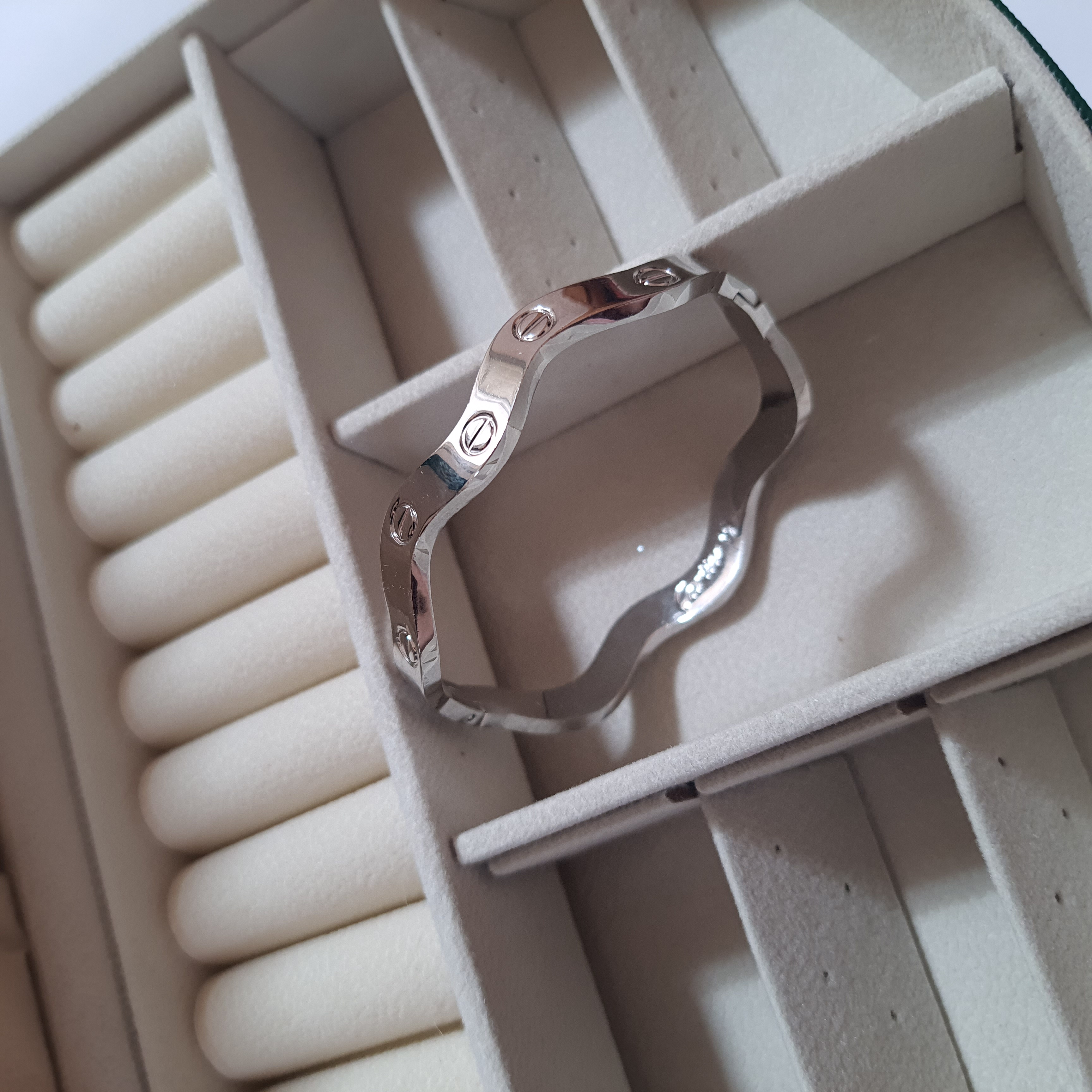 دستبند بنگل موجدار لولایی نقره‌ای براق با حکاکی Cartier | طراحی لوکس و مینیمال برند استینلس استیل