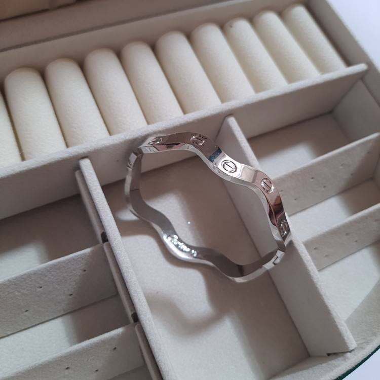 دستبند بنگل موجدار لولایی نقرهای براق با حکاکی Cartier | طراحی لوکس و مینیمال برند استینلس استیل