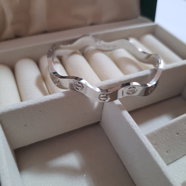 دستبند بنگل موجدار لولایی نقرهای براق با حکاکی Cartier | طراحی لوکس و مینیمال برند استینلس استیل